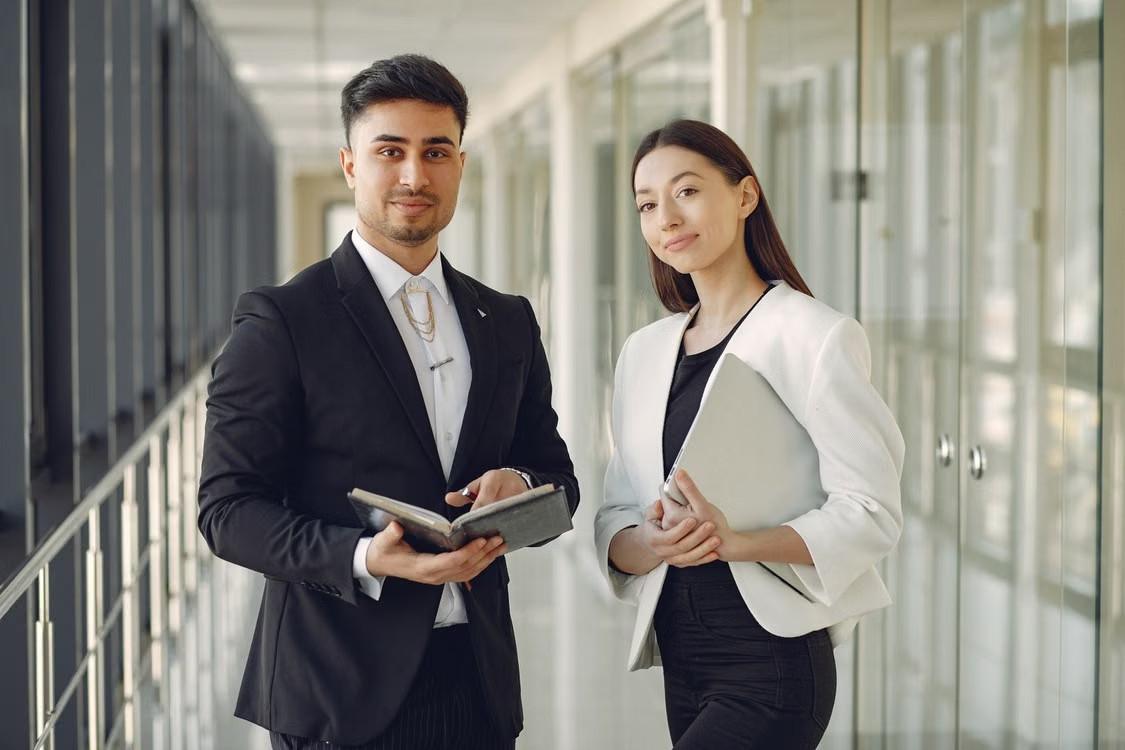 Two foreign professionals in a Bangkok office, ready to start work in Thailand