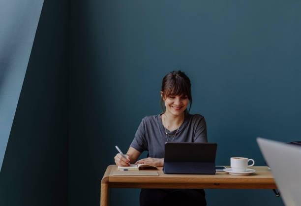 A foreign professional settling into a new role in Bangkok, working at a desk with a tablet and a coffee